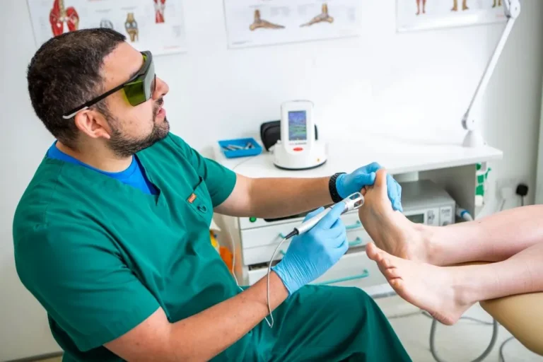 Tristan Valeny giving K-Laser treatment to a patient's foot